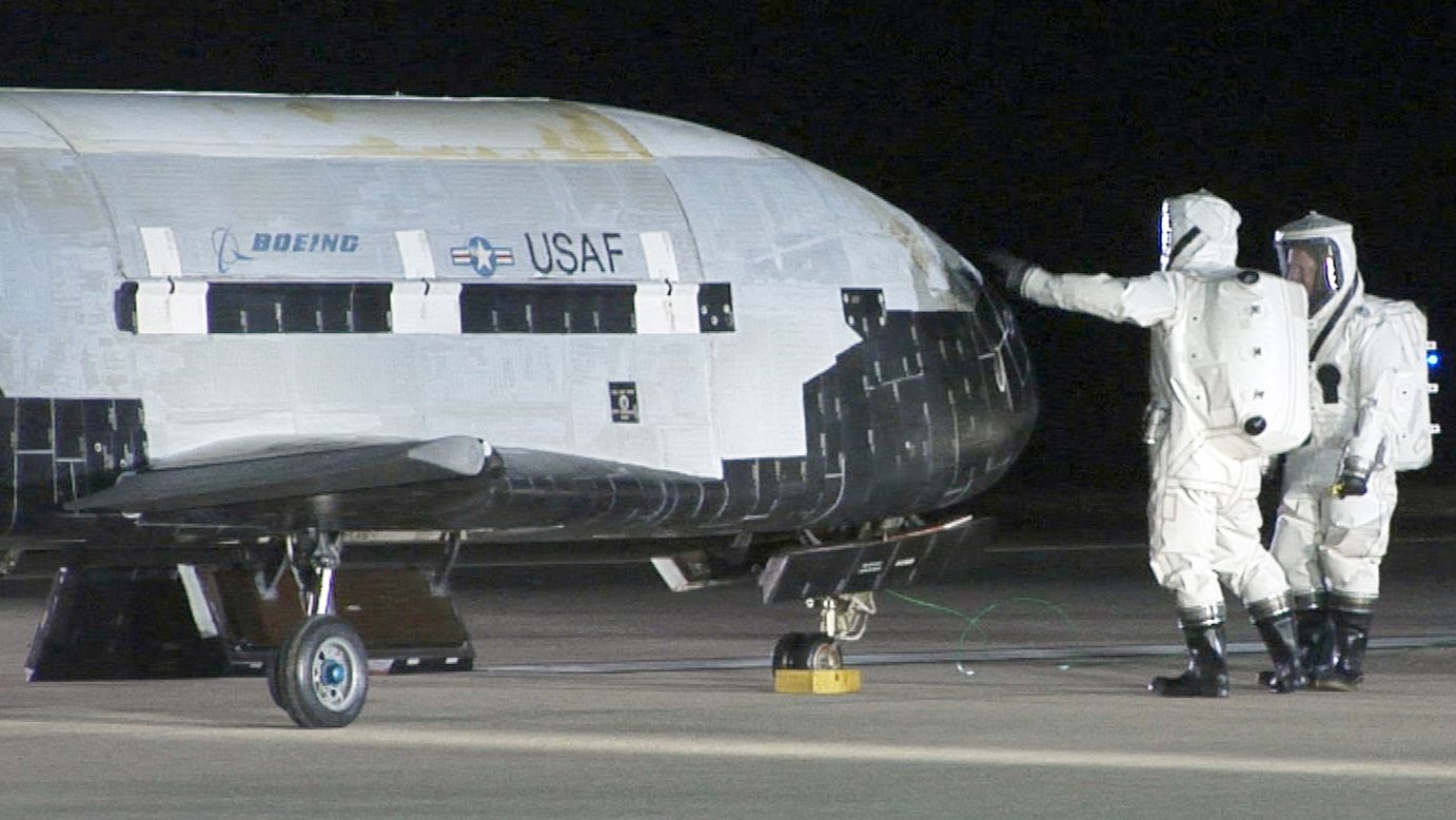 Technicians in self-contained atmospheric protective ensemble suits conduct initial checks on the X-37B after its landing on December 3, 2010.