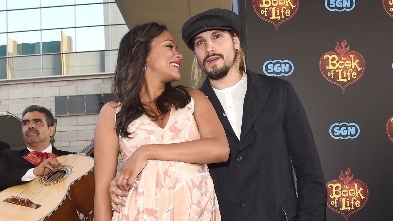 Zoe Saldana and husband Marco Perego share an affectionate moment on the red carpet of Saldana's new movie, "The Book of Life."