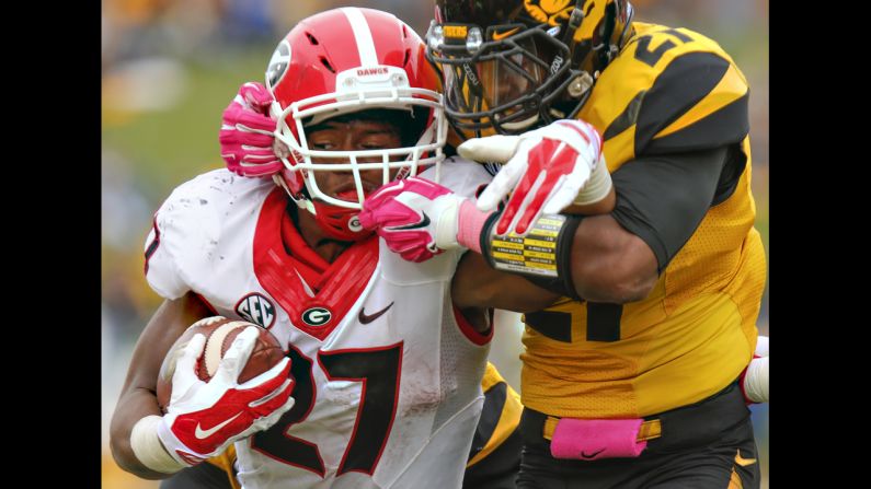 Georgia running back Nick Chubb has his helmet twisted by Missouri defensive back Ian Simon during a college football game Saturday, October 11, in Columbia, Missouri. Chubb, a freshman starting in place of suspended star Todd Gurley, rushed for 143 yards and a touchdown as the Bulldogs blanked Missouri 34-0.