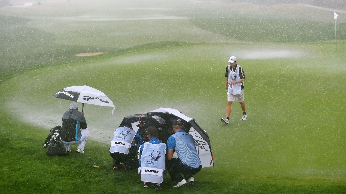 Golfers and their caddies try to block out heavy wind and rain during the final round of the Portugal Masters tournament in Vilamoura, Portugal, on Sunday, October 12. The 72-hole tournament was cut to 36 holes because of the weather conditions over the weekend.