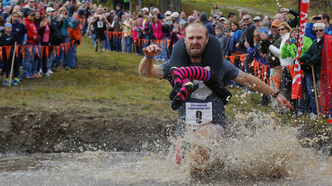 Jesse Wall carries Christina Arsenault through a water pit while competing in the North American Wife Carrying Championship, which took place Saturday, October 11, in Newry, Maine. Wall and Arsenault won the 278-yard obstacle race to qualify for the world championship in Finland. They aren't married, but that actually isn't required despite the event's name.