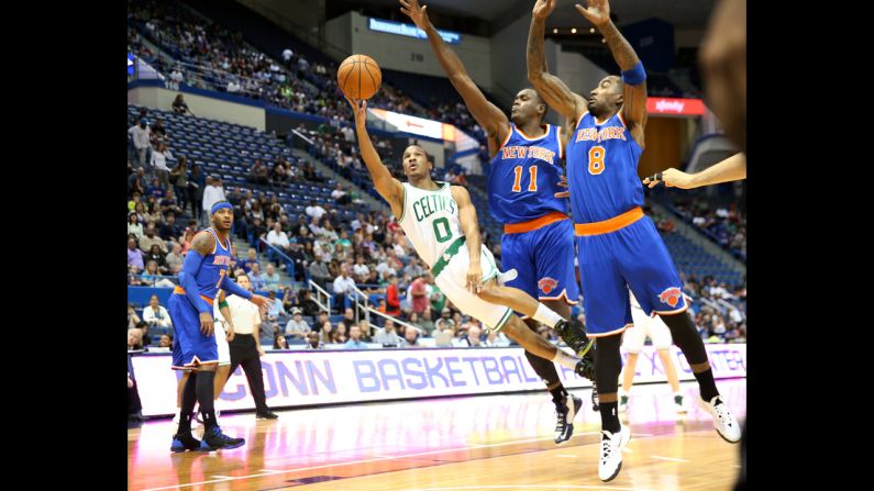Boston's Avery Bradley avoids two New York defenders as he gets a shot off during an NBA preseason game Wednesday, October 8, in Hartford, Connecticut.
