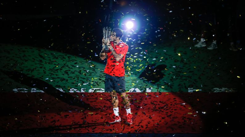 Tennis player Roger Federer celebrates with his trophy Sunday, October 12, after defeating Gilles Simon to win the Shanghai Rolex Masters in Shanghai, China.