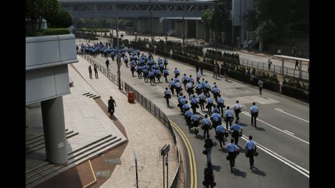 Police officers run to barricades set up by protesters on October 14.