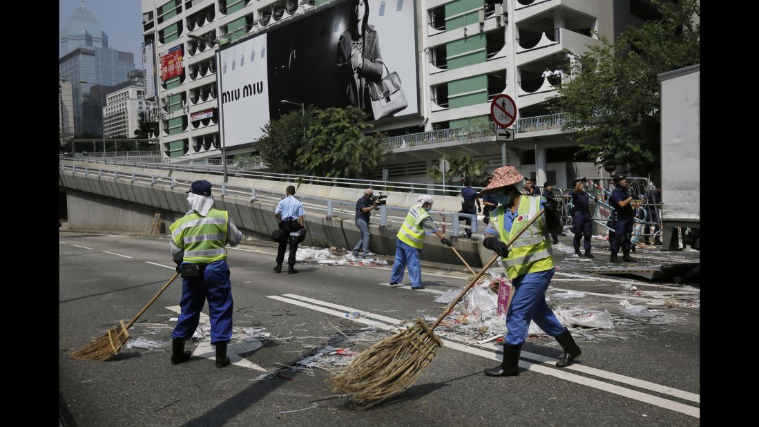 Cleaners sweep the main road after the police's removal of barricades on October 14.