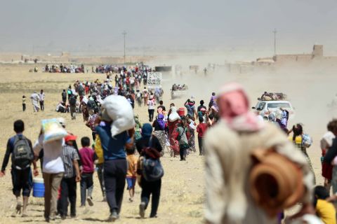 Thousands of Yazidis are escorted to safety by Kurdish Peshmerga forces and a People's Protection Unit in Mosul on Saturday, August 9.