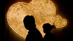 NANJING, CHINA - FEBRUARY 14: (CHINA OUT) A couple walk past hearts formed by 999 electric bulbs which were signed with people's autographs on Valentine's Day February 14, 2009 in Nanjing of Jiangsu Province, China. Valentine's Day has become one of the most popular Western festivals celebrated in China.  