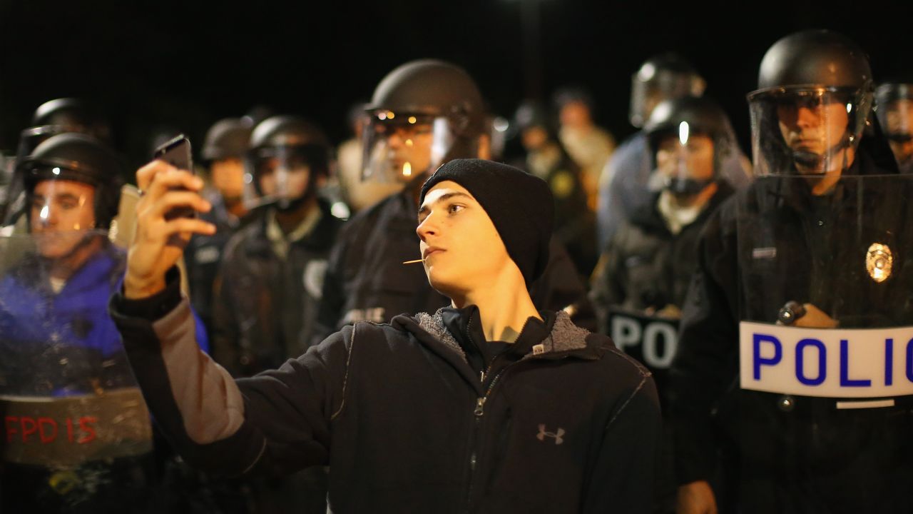 A protester takes a selfie in front of a police line during a demonstration outside the police department in Ferguson, Missouri, on Friday, October 10. Emotions have run high in the St. Louis suburb since Michael Brown, an unarmed black teenager, was fatally shot by Darren Wilson, a white police officer, in August. Protests <a href="http://www.cnn.com/2014/11/24/justice/gallery/ferguson-reaction/index.html">intensified in November</a> after a grand jury decided not to indict Wilson.
