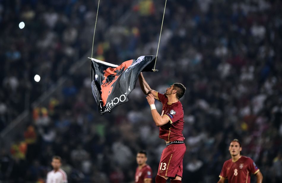 Serbia's Stefan Mitrovic grabs the "Greater Albania" flag dangling from a drone that flew over Tuesday's European Championships qualifying match between Serbia and Albania. The incident at Belgrade's Partizan Stadium precipitated a brawl that forced the referee to abandon the match. 