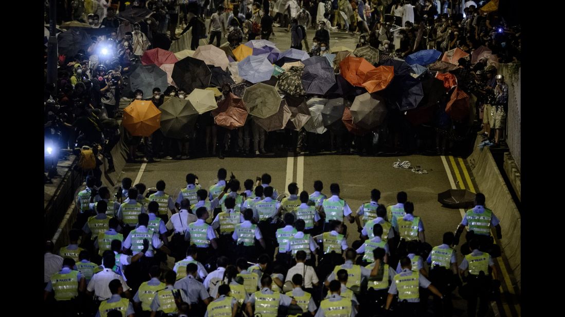 Police move toward pro-democracy protesters during a standoff outside central government offices on October 14.