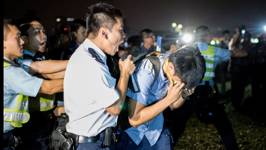 A police officer shouts into a microphone after a protester was hit with pepper spray on October 15.