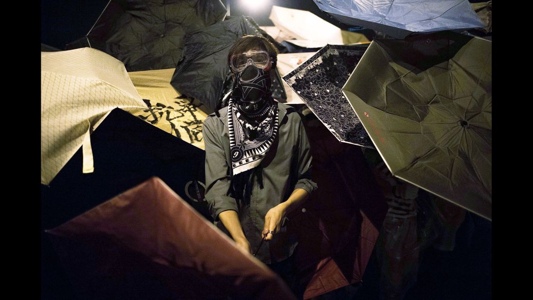 Pro-democracy protesters hide behind umbrellas to protect themselves from pepper spray on October 15.