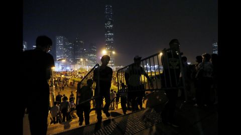 Protesters move barriers as others block a main road in Hong Kong with metal and plastic safety barriers on October 15.