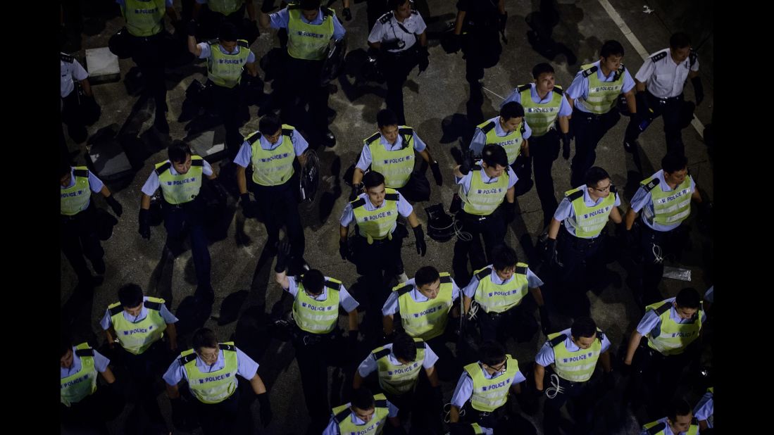 Police march toward pro-democracy protesters outside central government offices on October 15.