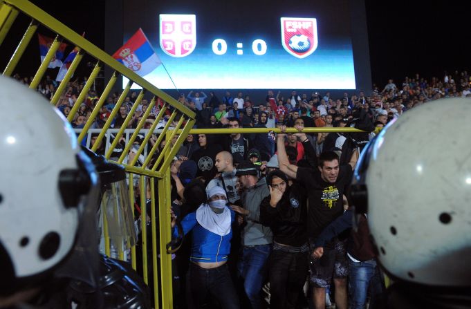 Riot police stand off against Serbian supporters as the situation escalates.