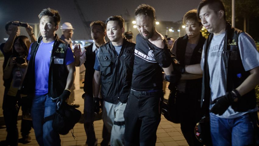 Civic Party member Ken Tsang, one of Hong Kong's pro-democracy political groups, is taken away by policemen, before being allegedly beaten up by police forces as seen on local TV footage shot outside the central government offices in Hong Kong on early October 15, 2014. Hong Kong police vowed on October 14 to tear down more street barricades manned by pro-democracy protesters, hours after hundreds of officers armed with chainsaws and boltcutters partially cleared two major roads occupied for a fortnight. AFP PHOTO / Philippe Lopez (Photo credit should read PHILIPPE LOPEZ/AFP/Getty Images)