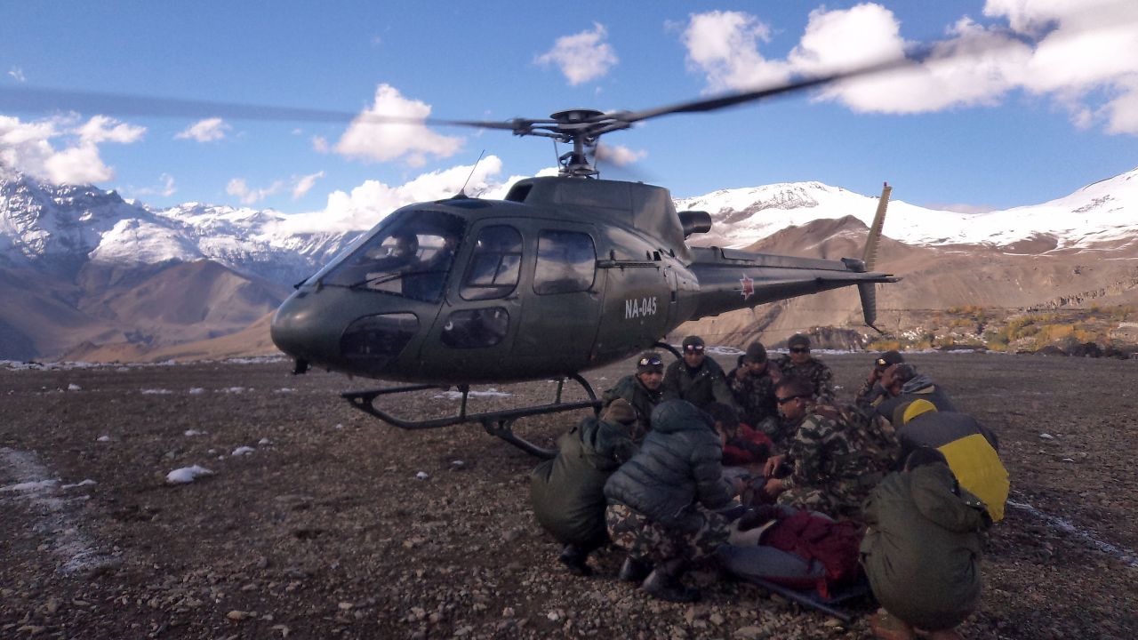 An injured survivor of a snowstorm is assisted by Nepal army personnel near the Annapurna range of the Himalayas. 