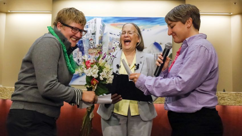 Rachael Beierle, left, and Boise City Council President Maryanne Jordan, center, laugh at a joke in Amber Beierle's wedding vows at City Hall in Boise, Idaho, on Wednesday, October 15. With Mayor Dave Bieter out of town, Jordan officiated the wedding as acting mayor. Ada County clerks began issuing marriage licenses to same-sex couples Wednesday morning.