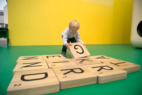 Children play with a giant scrabble set as part of Carsten Holler's installation "Gartenkinder", in which he the Gagosian Gallery's stand at Frieze was transformed into a children's playground.