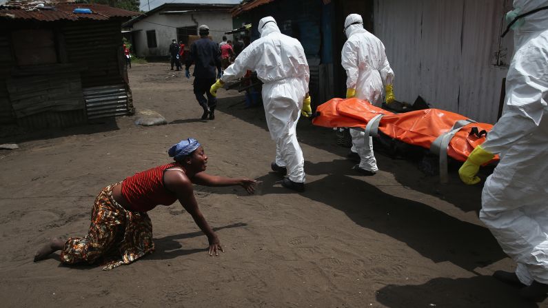 A woman crawls toward the body of her sister as a burial team takes her away for cremation Friday, October 10, in Monrovia, Liberia. The sister had died from Ebola earlier in the morning while trying to walk to a treatment center, according to her relatives. Health officials say <a href="http://www.cnn.com/2014/04/04/world/gallery/ebola-in-west-africa/index.html">the Ebola outbreak</a> in West Africa is the deadliest ever. More than 4,000 people have died there, according to the World Health Organization.