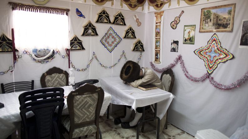 An ultra-Orthodox Jewish man sleeps in a sukkah, or hut, in Meah Shearim, Israel, on Friday, October 10. It was the second day of the Jewish holiday of Sukkot.