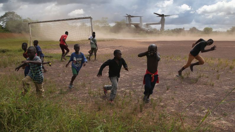Boys run from blowing dust as a U.S. military aircraft leaves the construction site of an Ebola treatment center in Tubmanburg, Liberia, on Wednesday, October 15. It is the first of 17 Ebola treatment centers to be built by Liberian army soldiers and American troops as part of the U.S. response to the epidemic.