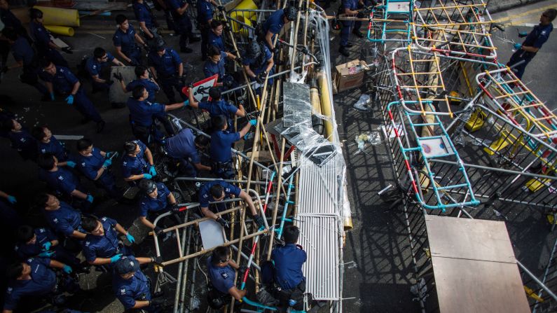 Police dismantle barricades on Queensway, a road in the Admiralty business district of Hong Kong, on Tuesday, October 14. The barricades were erected by <a href="http://www.cnn.com/2014/09/22/asia/gallery/hong-kong-students-protest/index.html">pro-democracy demonstrators</a> angry at China's decision to allow only Beijing-vetted candidates to run in the city's elections for chief executive.