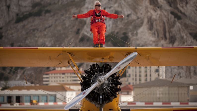 Tom Lackey, the world's oldest "wing walker" at 94, gestures after flying around the Rock of Gibraltar on Saturday, October 11.