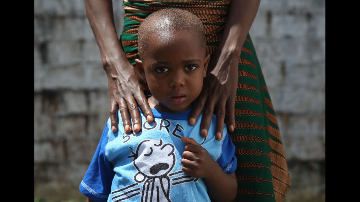 James Mulbah, 2, stands with his mother, Tamah Mulbah, 28, who also recovered from Ebola in the low-risk section of the Doctors Without Borders Ebola treatment center in Paynesville, Liberia.