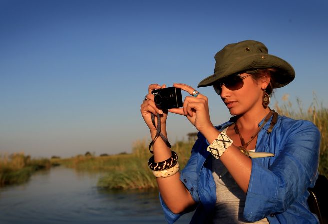 A woman on a boat ride in the Okavango Delta viewing various wildlife. Botswana relies heavily on tourism, and ecotourism in Botswana is said to contribule 4-5% towards the country's GDP. 