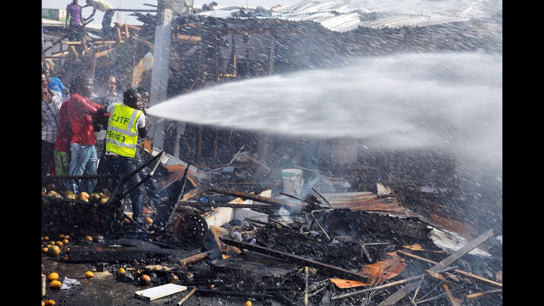 Rescue workers try to put out a fire after a bomb exploded at the busiest roundabout near the crowded Monday Market in Maiduguri on July 1, 2014.