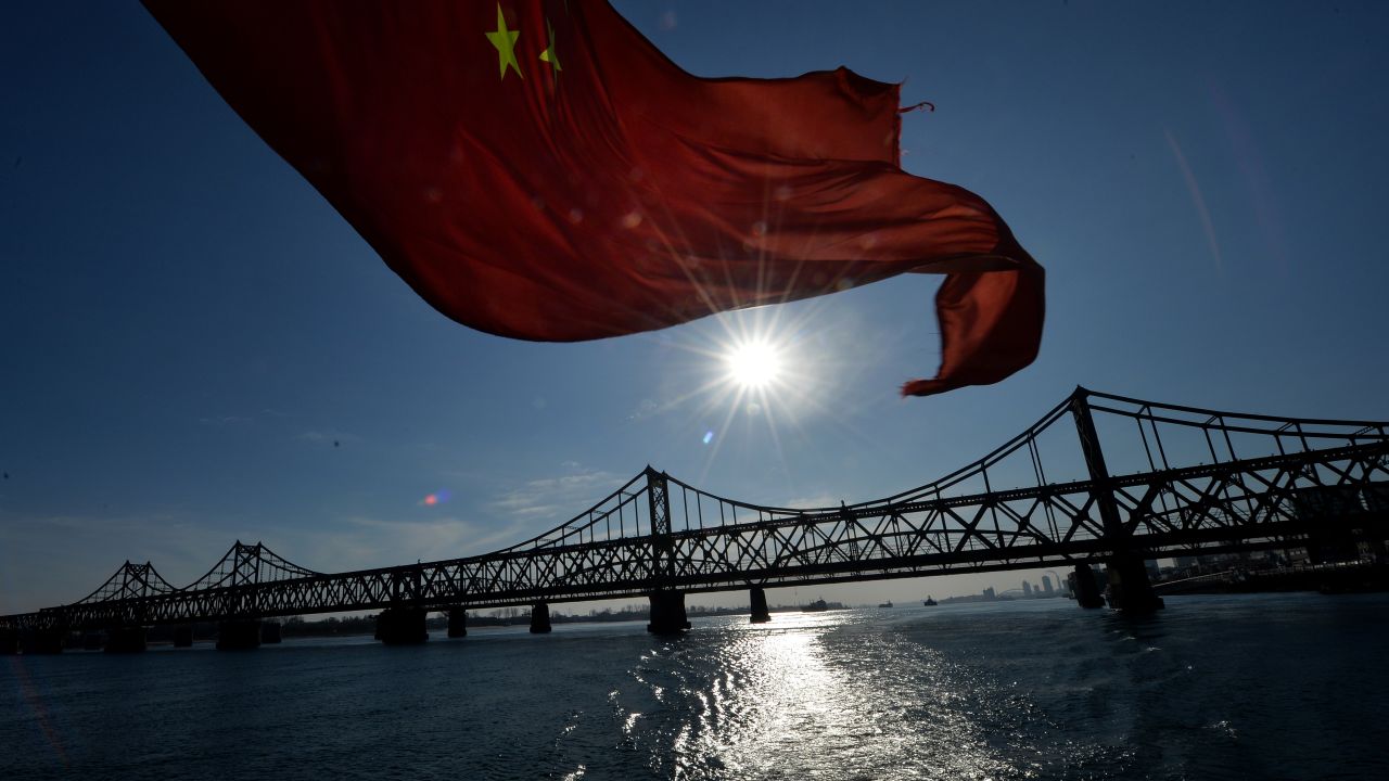 The Chinese flag flies from a boat beneath the Sino-Korean Friendship Bridge which leads to the North Korean town of Sinuiju from the Chinese border town of Dandong on December 16, 2013. 