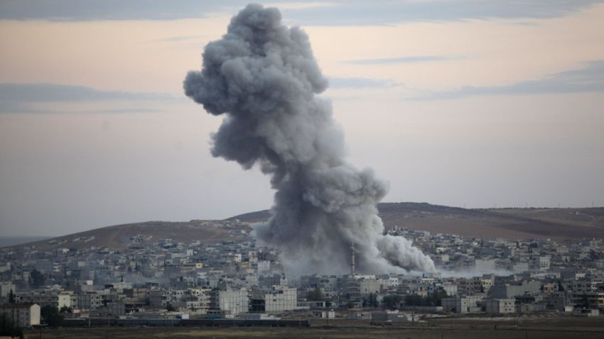 Caption:SANLIURFA, TURKEY - OCTOBER 18: (TURKEY OUT) Heavy smoke rises following an airstrike by the US-led coalition in Kobani, Syria, during fighting between Syrian Kurds and the militants of Islamic State group, as seen from the outskirts of Suruc, on the Turkey-Syria border, October 18, 2014. Kurdish fighters in Syrian city of Kobani have pushed back Islamic State militants in a number of locations as U.S. airstrikes on ISIS positions continue in and around the city. Since mid-September more than 200,000 people from Kobani flee into Turkey. (Photo by Gokhan Sahin/Getty Images)