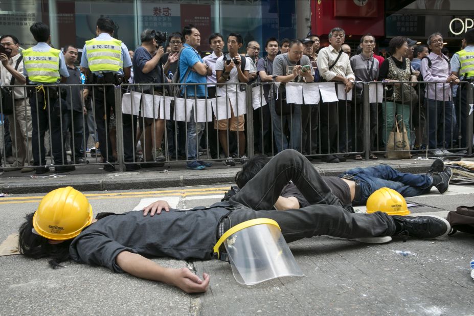 Pro-democracy protesters sleep next to a barricade on October 18 after reclaiming streets in Mong Kok after a night of violent scuffles with police.