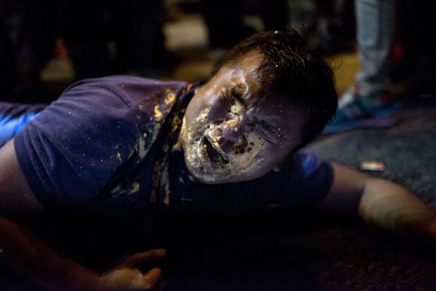 A journalist collapses in agony after being hit in the face with pepper spray during clashes with police on Friday, October 17. 