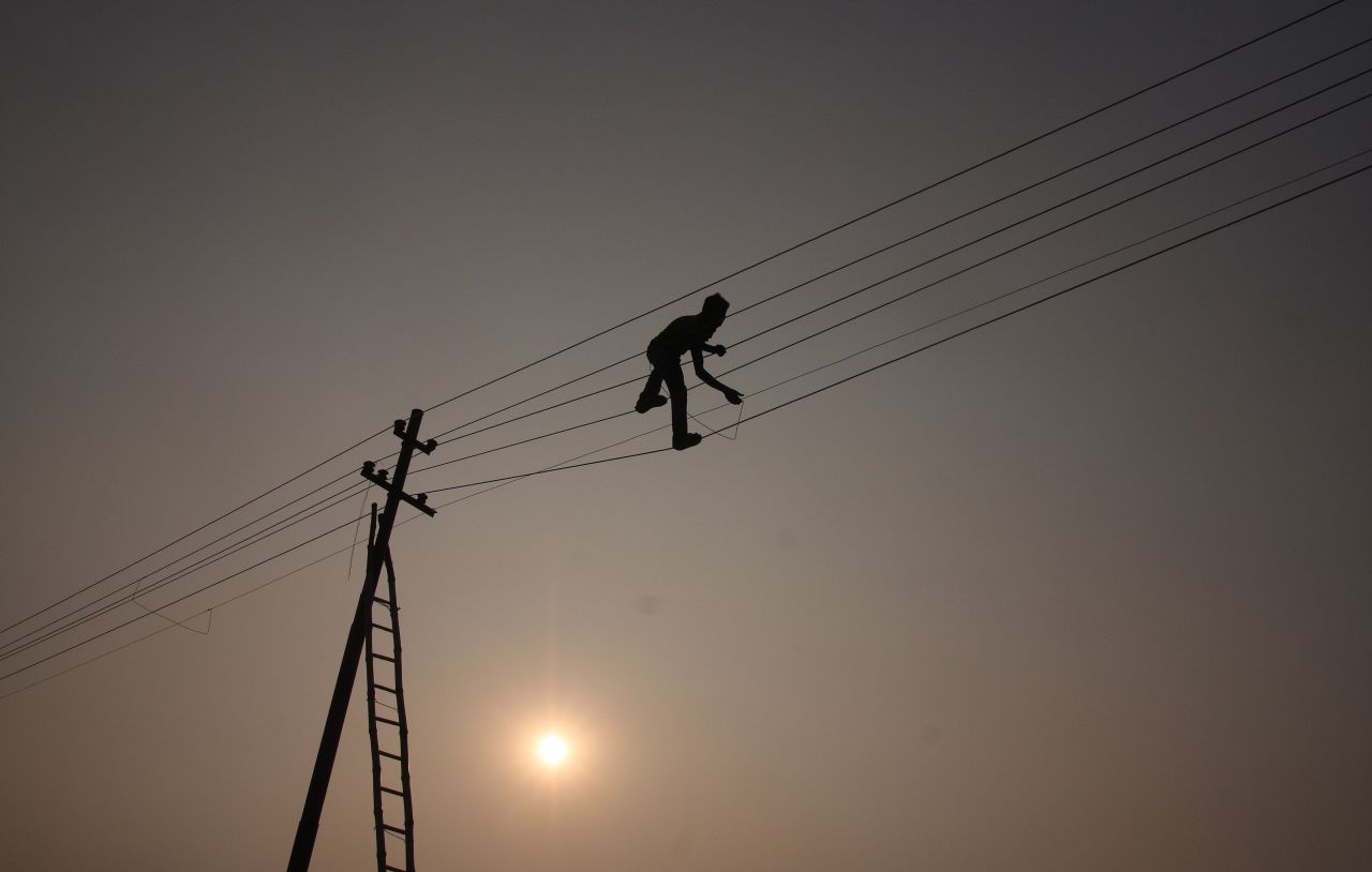 A workman attends to a power line in India. Energy theft remains a powerful disincentive for new investment in the sector.