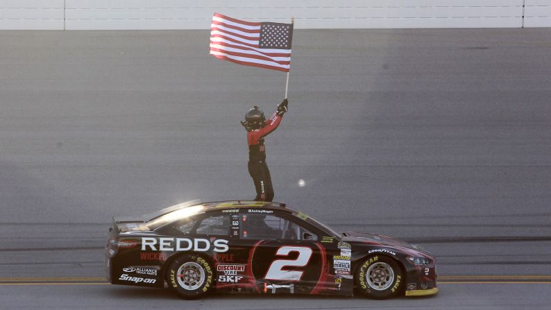 NASCAR driver Brad Keselowski waves the American flag as he celebrates winning a Sprint Cup race Sunday, October 19, in Talladega, Alabama. Keselowski's win kept him in the hunt for his second Sprint Cup championship in three years.