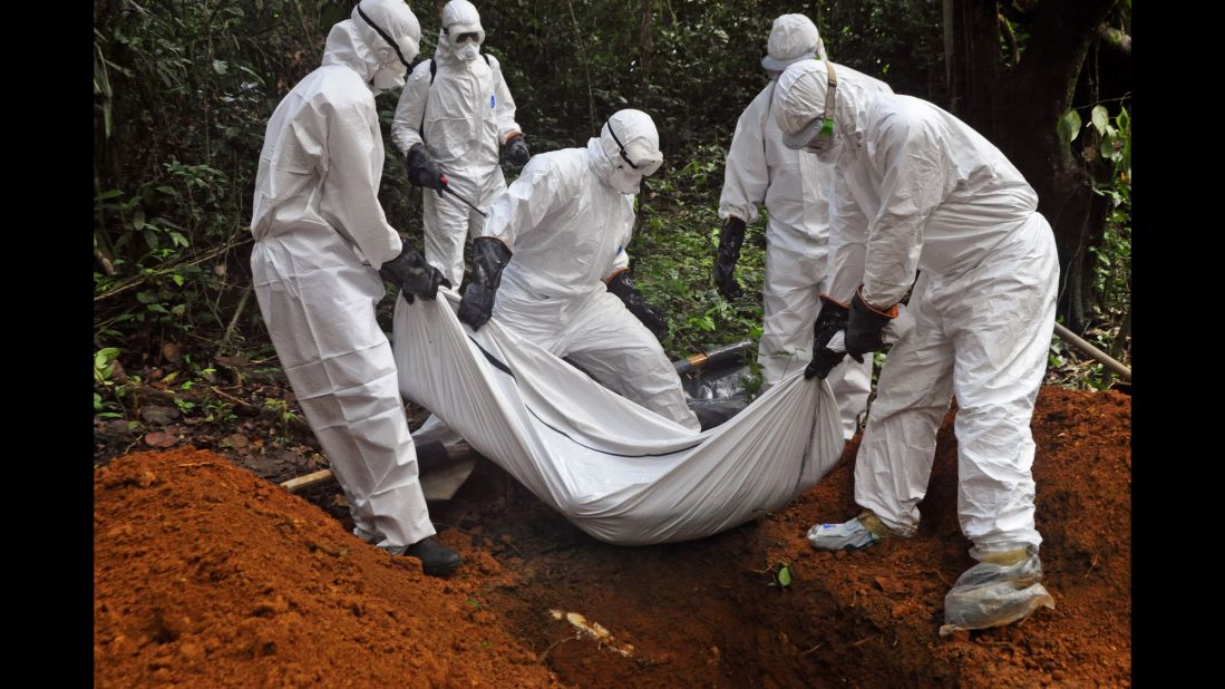 Health workers bury a body on the outskirts of Monrovia on October 20, 2014.