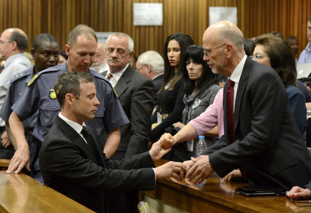 Oscar Pistorius reaches out to his uncle Arnold Pistorius and other family members as he is led out of court in Pretoria, South Africa, after being sentenced to five years in prison on Tuesday, October 21. Pistorius, the first double-amputee runner to compete in the Olympics, was sentenced for culpable homicide in the February 2013 death of his girlfriend, Reeva Steenkamp.