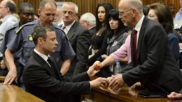 Oscar Pistorius, left front, greets his uncle Arnold Pistorius, right, and other family members as he is led out of court in Pretoria, South Africa, Tuesday, Oct. 21, 2014. Pistorius received a five-year prison sentence for culpable homicide by judge Thokozile Masipais for the killing of his girlfriend Reeva Steenkamp last year (AP Photo/Herman Verwey/Pool)