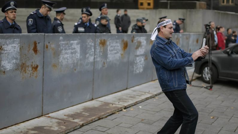 A member of Ukrainian trade unions takes a selfie in front of police as he attends a rally in front of the Ukrainian Cabinet building in Kiev on Wednesday, October 15.
