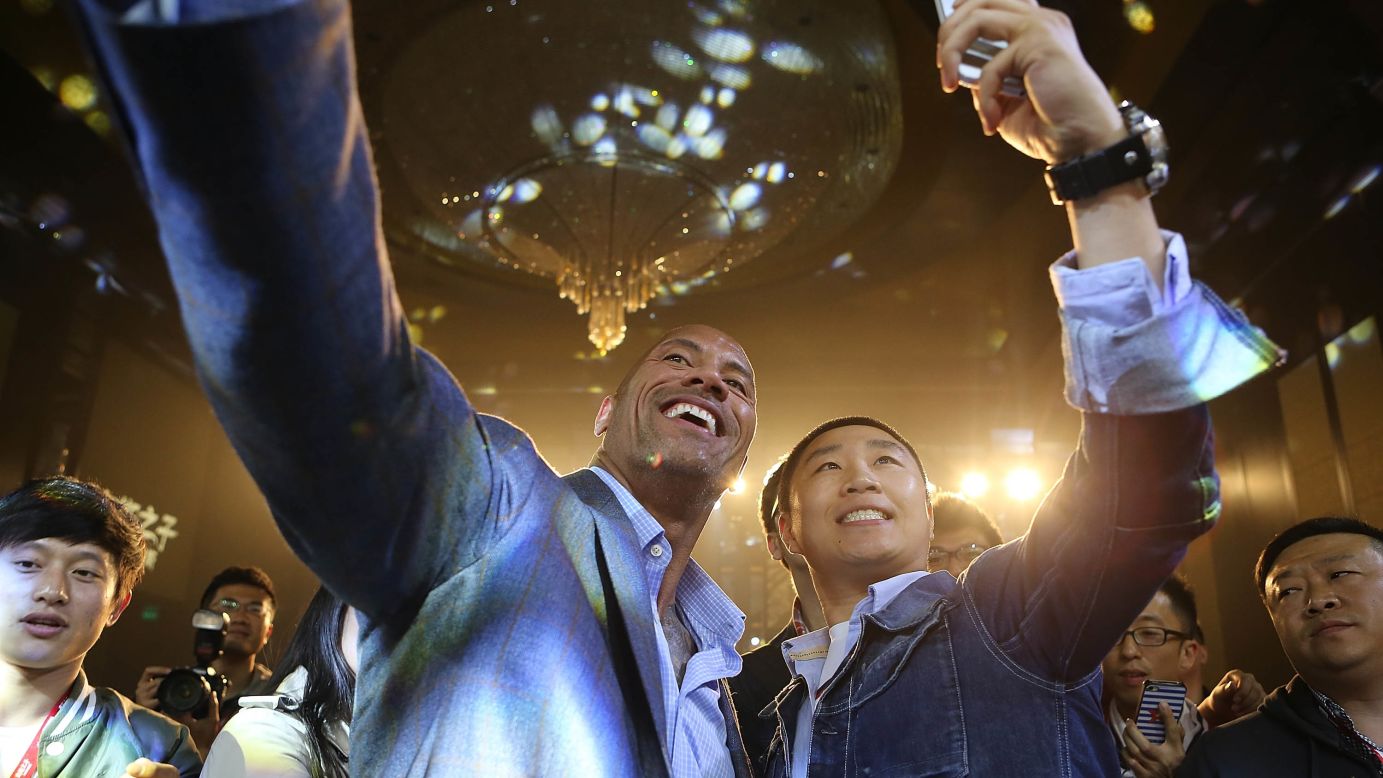 Actor Dwayne Johnson, center left, takes a selfie at a Beijing hotel where a media event was being held for the movie "Hercules" on Thursday, October 16.