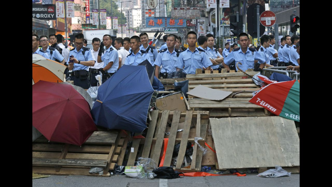Riot police stand guard near a barricade in a protester-occupied area on Wednesday, October 22. 