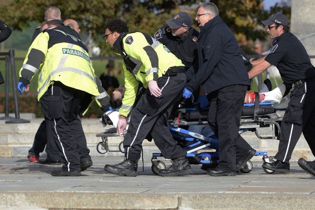 Paramedics and police pull a shooting victim away from the war memorial.