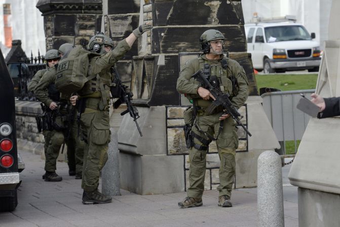 Police walk past a gate on Parliament Hill.