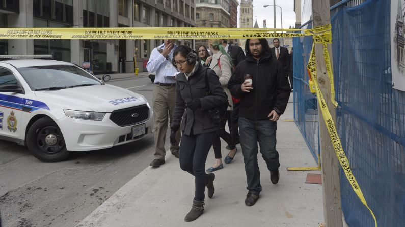 Civilians leave a secured area around Parliament Hill.