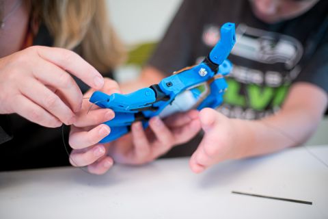 A parent and a child examine a new hand built by a 3-D printer.<a href="http://www.cdc.gov/ncbddd/birthdefects/ul-limbreductiondefects.html" target="_blank" target="_blank"> Four out of every 10,000 children</a> are born with some kind of upper limb abnormality. This hand is for children with a palm and wrist but no fingers. When the child bends his wrist, he makes a fist.