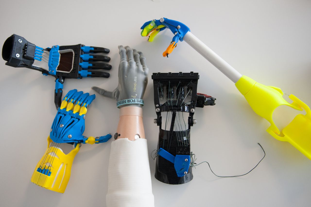 The i-limb ultra (center) is a top-of-the-line electronic prosthetic that <a href="http://www.cnn.com/2013/02/01/tech/bionic-hand-ilimb-prosthetic/">costs $100,000</a>. Surrounding it are body-powered devices developed and built by a community of e-NABLE volunteers for roughly $150 a hand.