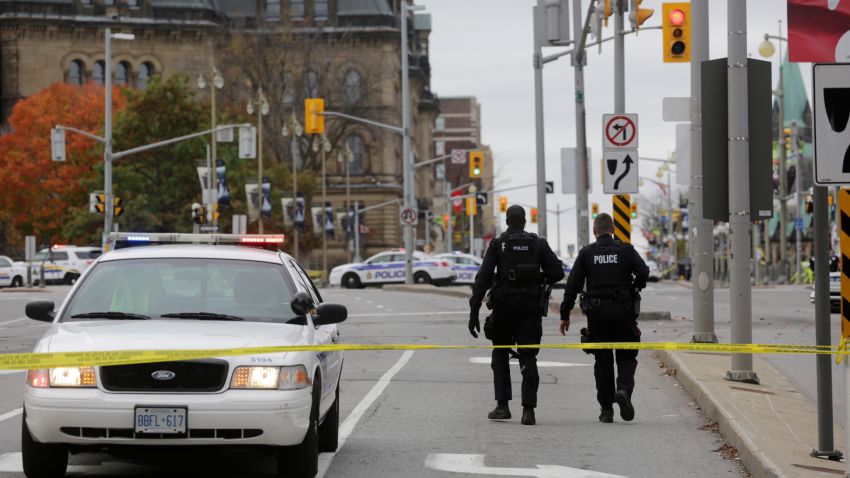 OTTAWA, CANADA - OCTOBER 22:  Ottawa police officers walk up Wellington St. near the National War Memorial where a soldier was shot earlier in the day, just blocks away from Parliament Hill, on October 22, 2014 in Ottawa, Canada. Officials are investigating multiple reports of shootings and suspects after at least one gunman shot a Canadian soldier and then entered Canada's Parliament building.   (Photo by Mike Carroccetto/Getty Images)