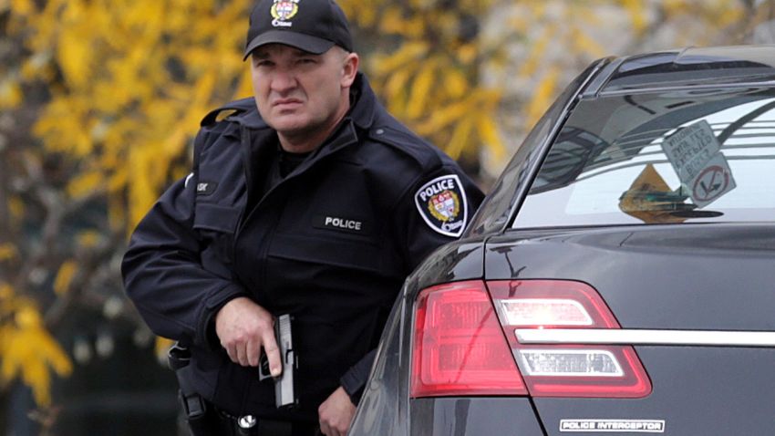 OTTAWA, CANADA - OCTOBER 22: A police officer stands guard on Wellington St. in downtown, October 22, 2014 in Ottawa, Canada. Officials are investigating multiple reports of shootings and suspects after at least one gunman shot a Canadian soldier and then entered Canada's Parliament building. (Photo by Mike Carroccetto/Getty Images)